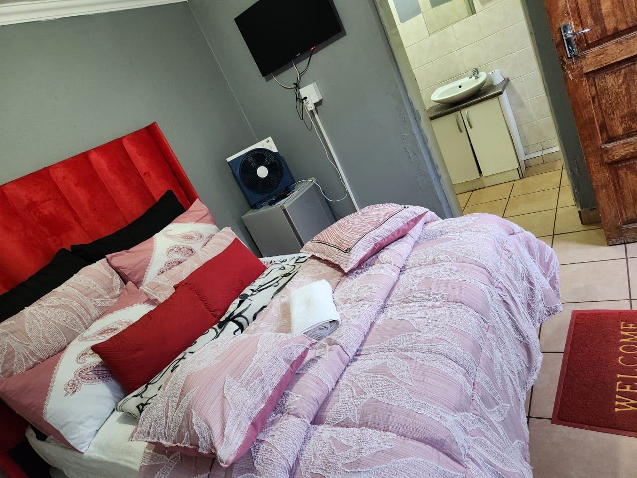 Room with red headboard and TV